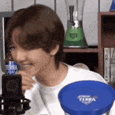 a woman is smiling in front of a terra light bottle