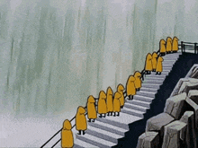 a group of people in yellow raincoats are standing on a set of stairs next to a waterfall .