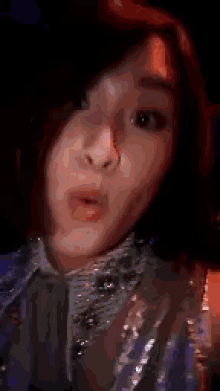 a woman with red hair is wearing a blue jacket and making a face .