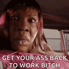 a woman is sitting in the back seat of a car with a pink shirt on .