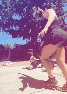 a woman is riding an exercise bike in front of a sign that says ' i love you ' on it