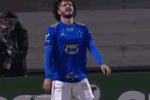 a soccer player wearing a blue shirt with bh on the front