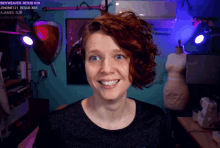 a woman with red hair is smiling in front of a screen that says sidyweaver on it