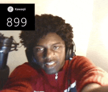 a man wearing headphones looks at the camera with the number 899 in the corner