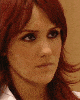 a woman with red hair has a nose ring in her nose