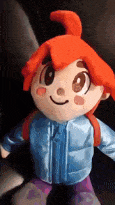 a stuffed doll with red hair is wearing a blue jacket and purple pants