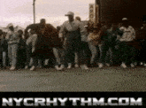 a group of people are dancing on a street and the website nycrhythm.com is displayed