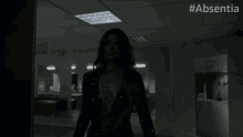 a man is holding a woman in a room with the hashtag absentia on the bottom right