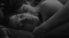 a man and a woman are sleeping next to each other in a bed .