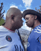 two men are looking at each other and one is wearing a shirt that says paris saint-germain