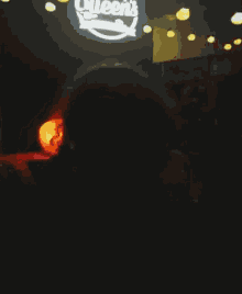 a neon sign in a dark room that says queen 's