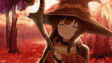 a girl in a witch 's hat is smiling while holding a staff in a forest .