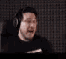 a blurry picture of a man wearing headphones and a black shirt .