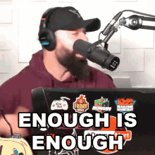a man wearing headphones speaking into a microphone with the words enough is enough behind him
