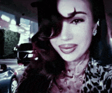 a close up of a woman 's face with a car behind her