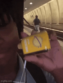 a person is holding a yellow box that has a circle on it