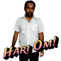 a man in a white shirt is standing next to a sign that says hari om
