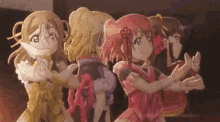 a group of anime girls are standing next to each other clapping their hands .