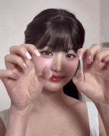 a woman with pink and white nails is covering her face