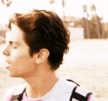 a close up of a man 's face with a pink shirt on