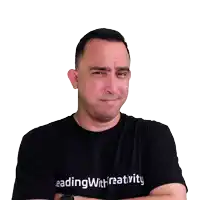 a man wearing a black reading with creativity shirt looks down