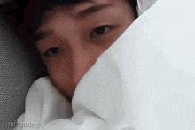 a close up of a man 's face covered by a white blanket .