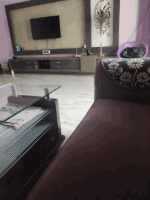a living room with a purple couch and a black and white floral pillow