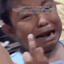 a little boy is crying and giving the middle finger