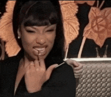 a woman with a ring on her finger is smiling and eating a lollipop