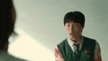 a young man in a school uniform with blood on his shirt is talking to another person .