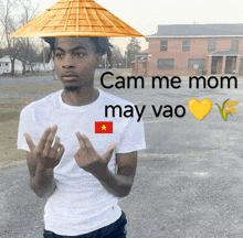 a man wearing a conical hat with cam me mom may vao written on it