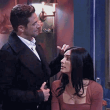 a man and a woman are standing next to each other in a room .