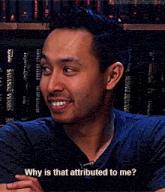 a man in a blue shirt is smiling and asking " why is that attributed to me "
