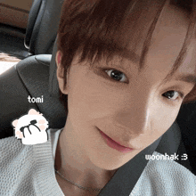 a close up of a person 's face with tomi and woonhak written on it