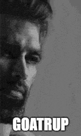 a black and white photo of a man with a beard and the words `` goatrup '' on his face .