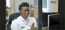 a man wearing a name tag that says hope is sitting in front of a computer .