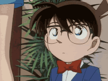 a boy with glasses and a red bow tie looks at the camera