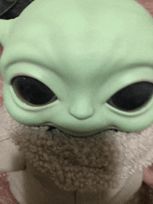 a close up of a toy that looks like a green alien