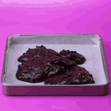 a tray of brownies is sitting on a pink surface with the words mr.cakes on the bottom