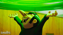 a smurf is laughing with his arms outstretched in front of a wooden wall