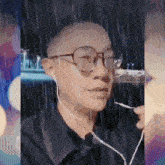 a man wearing glasses and ear buds looks at the camera in the rain