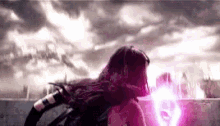 a woman in a superhero costume is standing in front of a pink light .