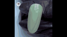 a close up of a green nail with a black glove