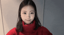 a young woman wearing a red sweater is smiling