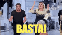 a man and a woman are standing next to each other with the word basta on the screen