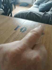 a close up of a person 's hand on a wooden table