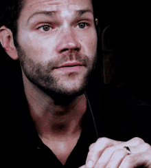a man with a beard is wearing a wedding ring on his finger