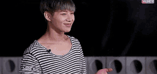 a young man in a striped shirt is crying while holding a ring in his hands .
