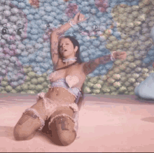 a woman is kneeling down in front of a floral wall