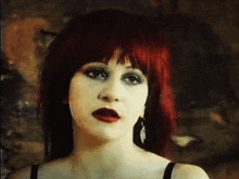 a close up of a woman with red hair and red lipstick